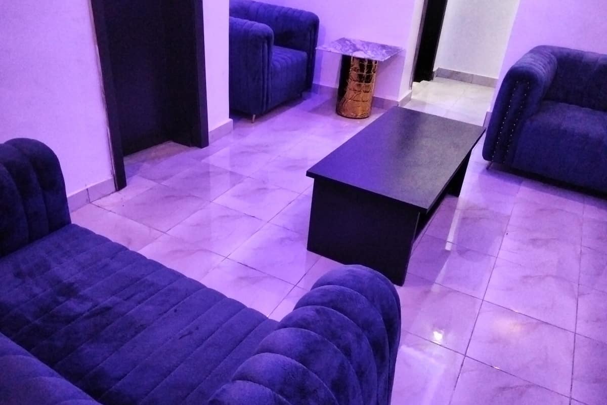 A room with two blue sofas, a black coffee table, and a small side table.