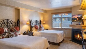 A hotel room with two beds, a fireplace, and a large window with a city view. - Silverado Suit - Steps to Canyons, Golf & Trails (Park City)