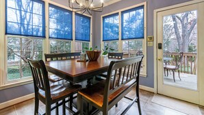 A dining area with a wooden table, chairs, and a chandelier.