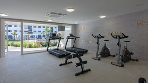 Una palestra con tapis roulant, cyclette e macchinari per l'allenamento con i pesi.