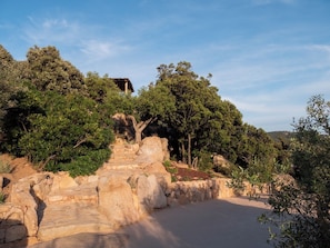 A stone staircase leading up a hill with trees and a building in the background. - Charming sheepfold in Corsica, heated pool, between scrubland and beautiful beaches. (Figari)