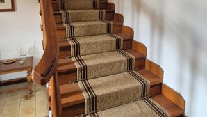 Eine Holztreppe mit Teppich belegten Stufen und einem Holzgeländer.