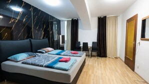 Ein Hotelzimmer mit Bett, Schreibtisch, Stuhl und Tür.