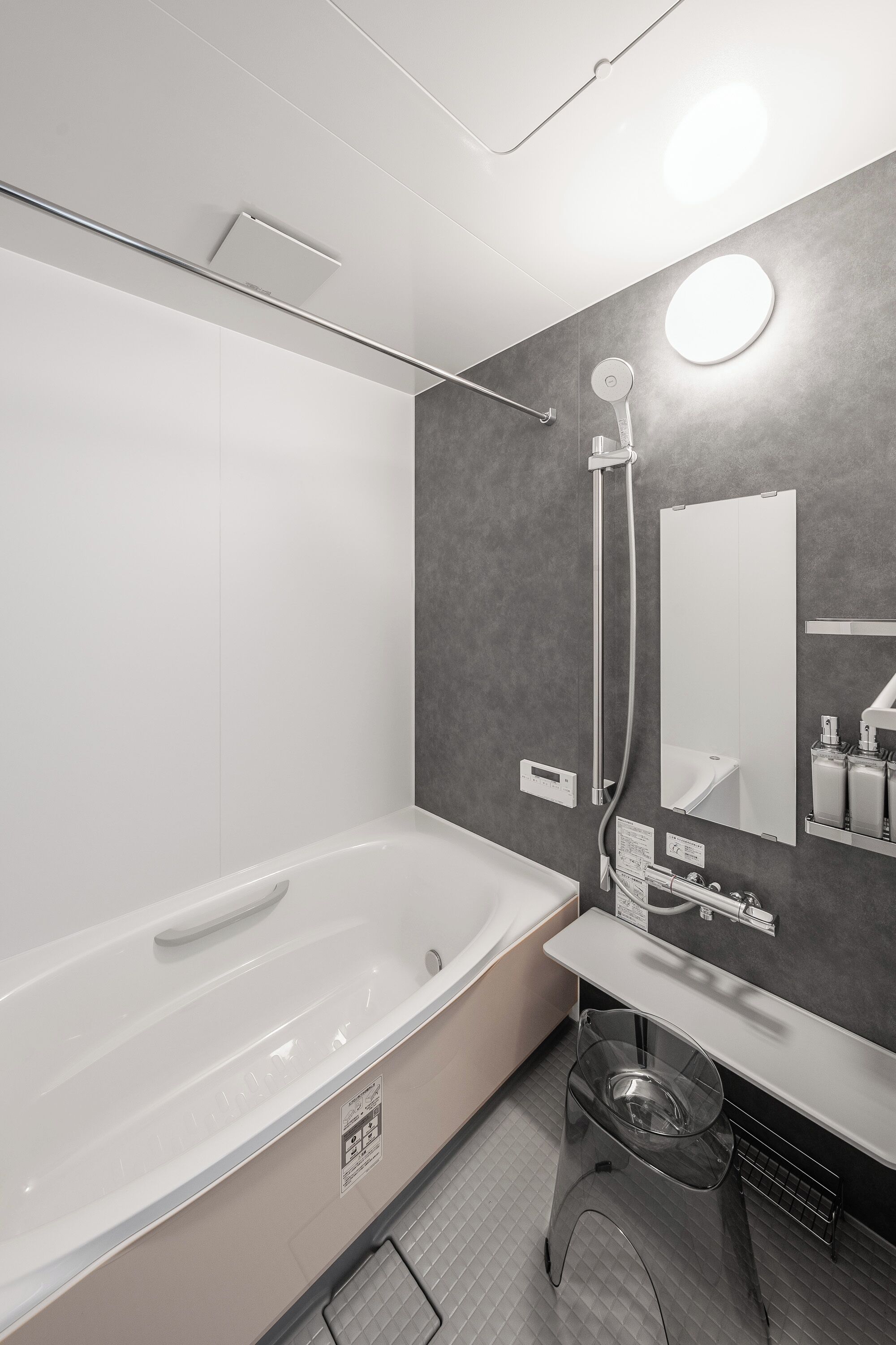 Ein modernes Badezimmer mit einer großen Badewanne, einer Dusche und einem Waschtisch mit Spiegel.