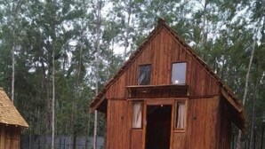 Una cabana de fusta amb un porxo frontal i una escala que porta a l'entrada.