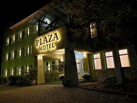Un edificio con un letrero que dice "Plaza Hotel" de noche.