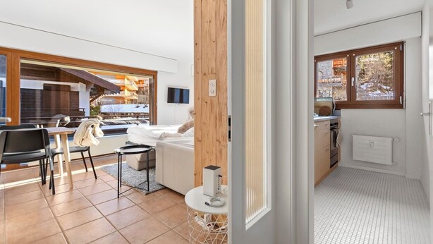 Habitación de hotel moderna con cama, una mesita y vista al exterior.