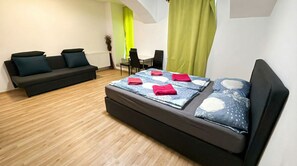 Un dormitorio moderno con cama, sofá, mesa de comedor y sillas.