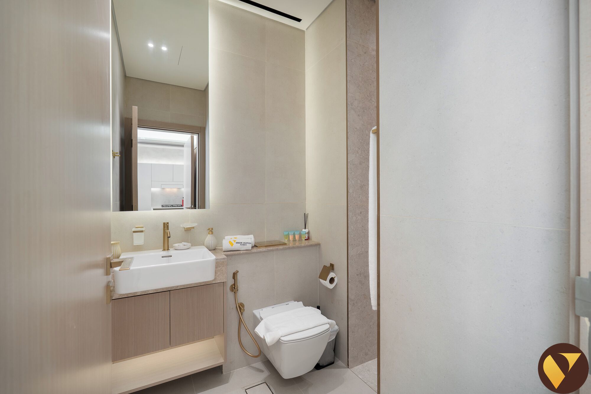 A modern bathroom with a sink, mirror, and toilet.