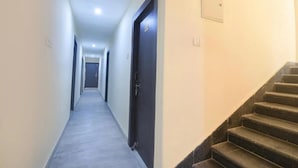 A narrow hallway with a carpeted floor and a dark door on the right. - Hotel Magadh Crystal (Patna)