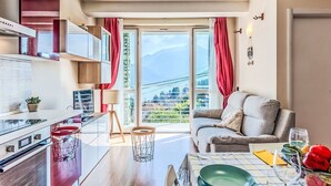 Una cocina moderna con comedor, un sofá y vistas a las montañas.
