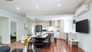 Un appartement moderne comprenant un coin repas, une cuisine et un salon.