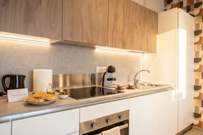 A modern kitchen with a built-in stove, a sink, and a coffee maker. - Urban penthouse with a terrace and parking space (Bari)