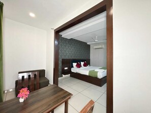 Ein Hotelzimmer mit Bett, Schreibtisch und Stuhl.