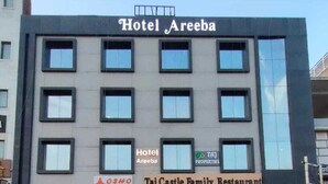 En byggnad med flera våningar, med en skylt som visar att det är Hotel Areeba och Taj Castle Family Restaurant.