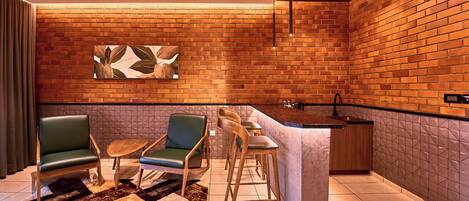 A modern interior with a brick wall, a bar area, and seating arrangements.