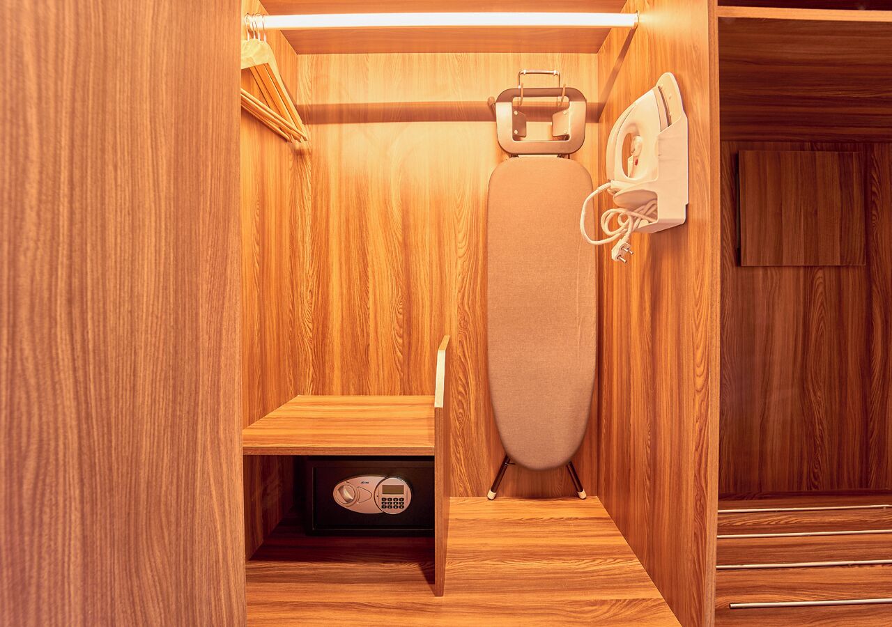 A wooden interior with a built-in ironing station and a control panel.