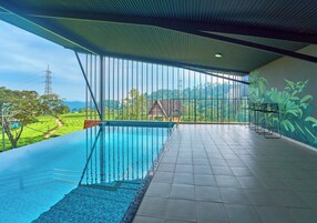 Una piscina interior moderna con vistas a un paisaje exuberante.