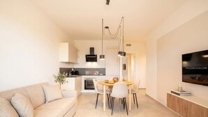 Un espace de vie moderne comprenant un canapé, une table à manger et un coin cuisine.
