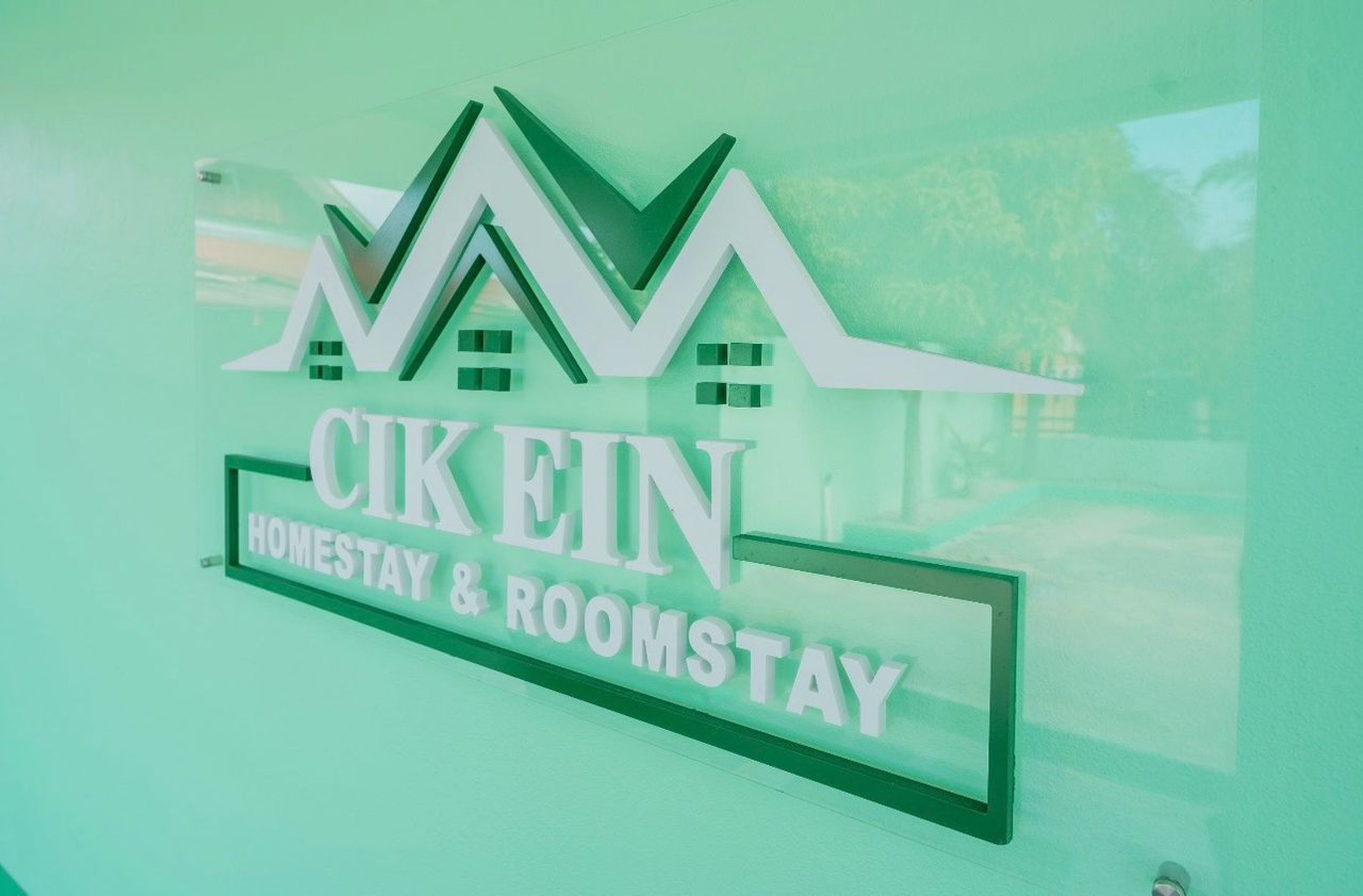 A sign with the text "Cikein Homestay & Roomstay" and a stylized house graphic.
