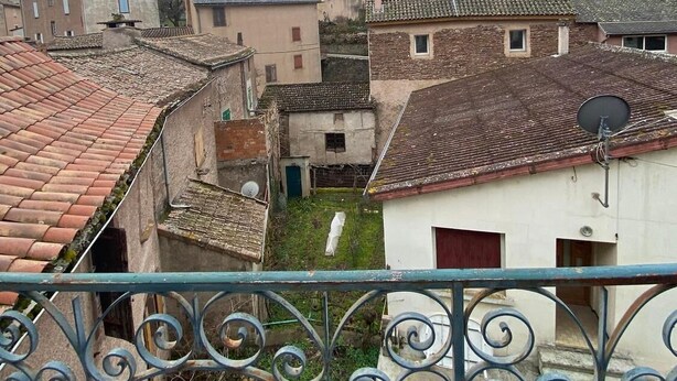 Une vue d’une ville à l’architecture traditionnelle, avec notamment un clocher d’église imposant et une cour entourée de bâtiments.