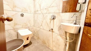 Een badkamer met toilet, bidet en wastafel.