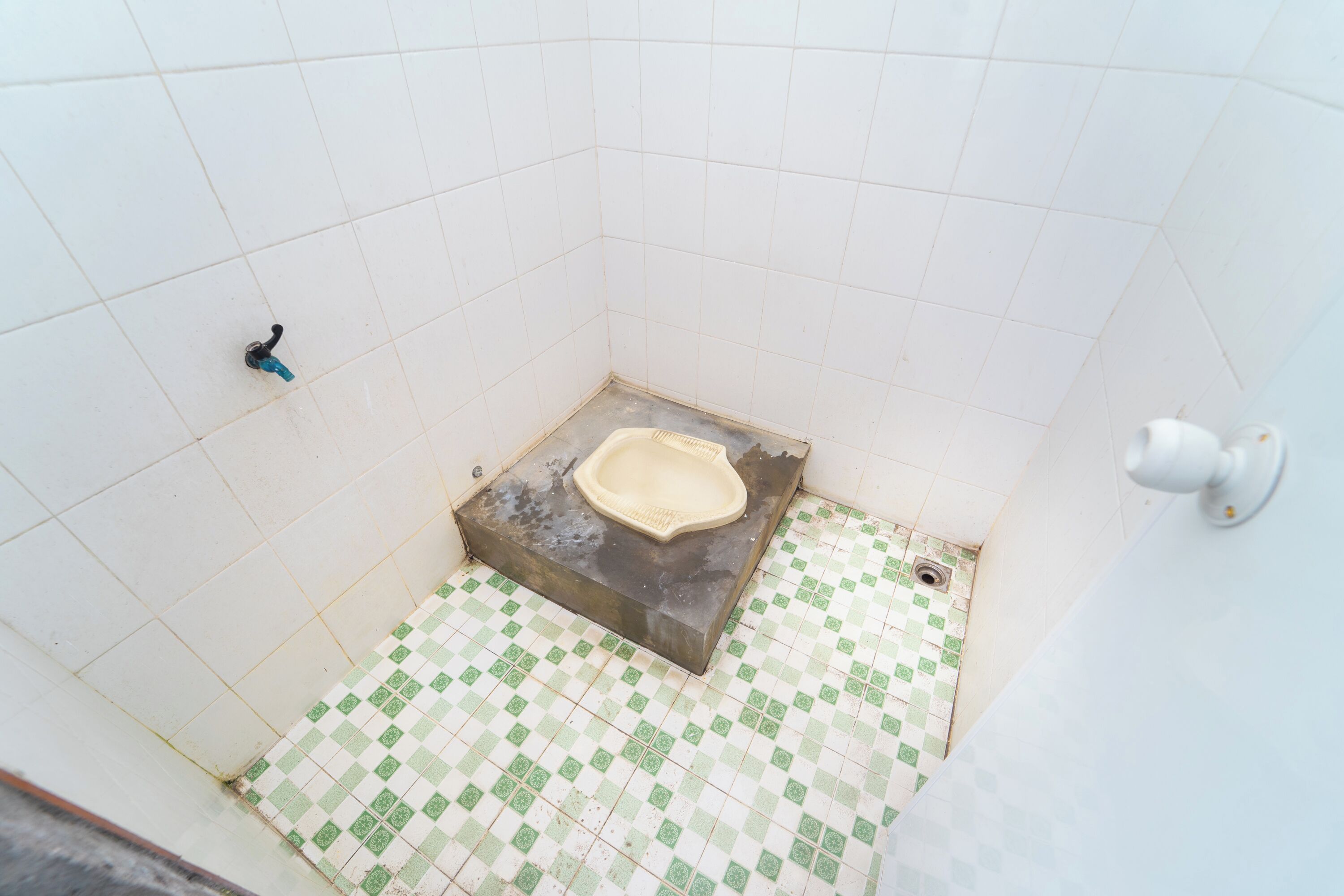 Um banheiro pequeno com azulejos, vaso sanitário, pia e chuveiro.