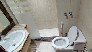Une salle de bain avec un lavabo, des toilettes et une douche.
