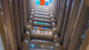 Un atrium à plusieurs niveaux, agrémenté de colonnes décoratives, d’ascenseurs et d’espaces aménagés pour s’asseoir.