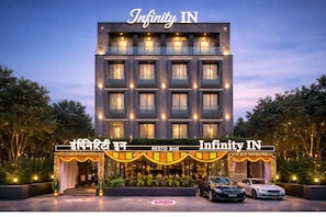 Un immeuble à plusieurs étages abritant un restaurant-bar au rez-de-chaussée, caractérisé par un design moderne avec un toit plat et de grandes fenêtres.