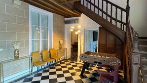 Una habitación con suelo a cuadros, una escalera de madera y una mesa de fútbol de mesa.