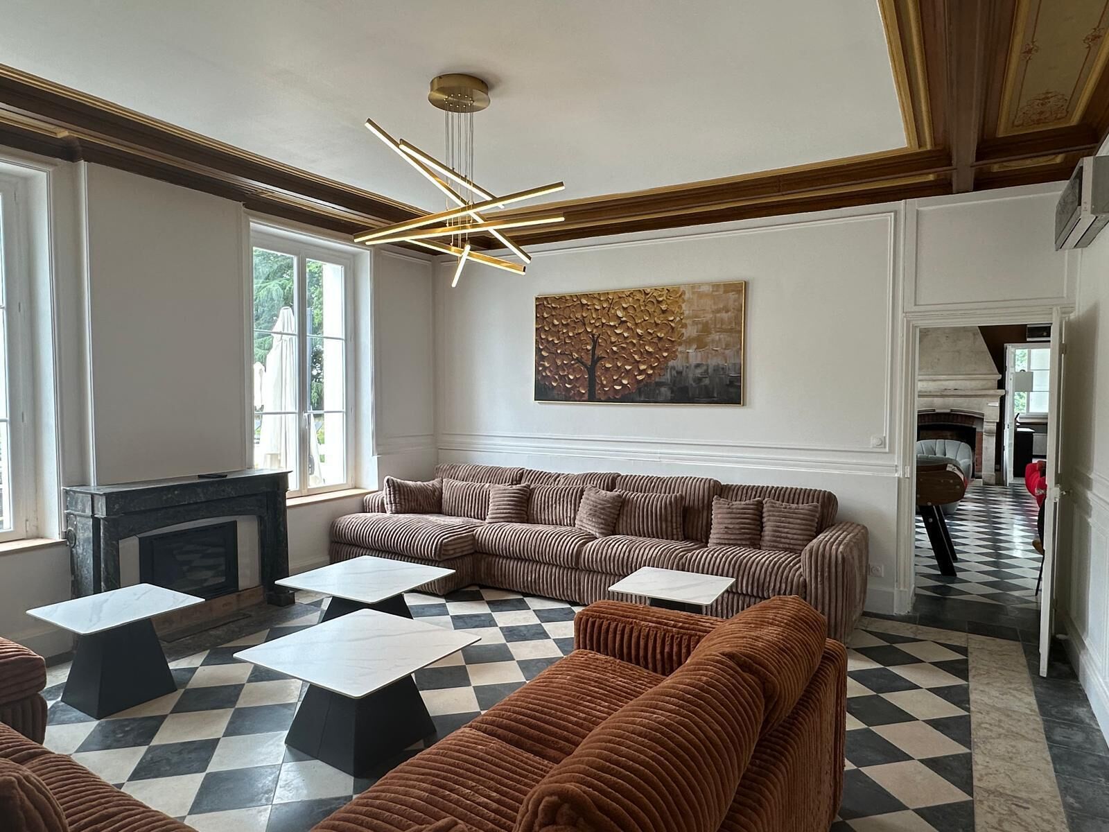 A modern living room with a checkered floor, striped sofas, and a fireplace.