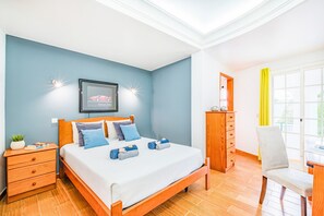 A hotel room with a bed, bedside tables, a dresser, a chair, and a window with curtains. - Sophisticated villa with BBQ and heatable pool (Armação de Pêra)
