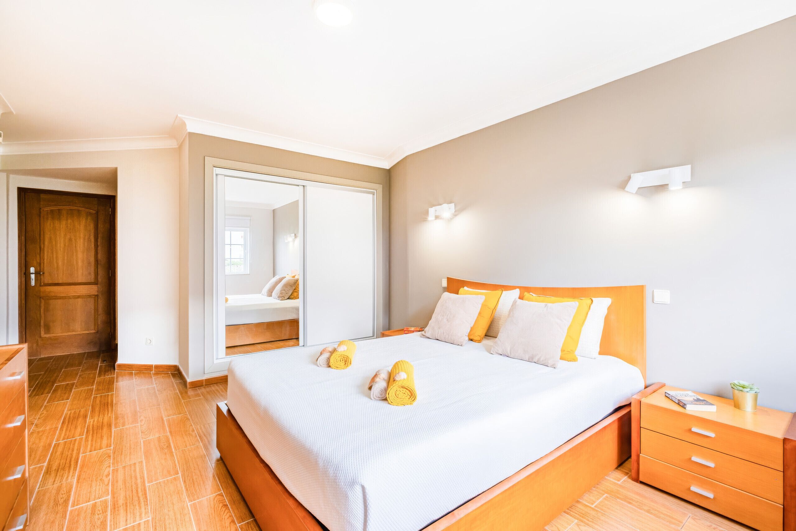 Ein Hotelzimmer mit einem Bett, einem Nachttisch aus Holz, einem Beistelltisch und einem Kleiderschrank.
