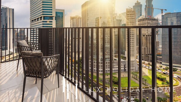 A balcony with a view of Dubai's skyline, including modern buildings and a construction crane. - LUX The Business Bay Executive Suite (Dubai)