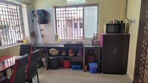 Une cuisine compacte avec un coin repas, un four à micro-ondes et une cuisinière à gaz.