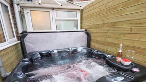 Een hottub met een houten wand en een raam.