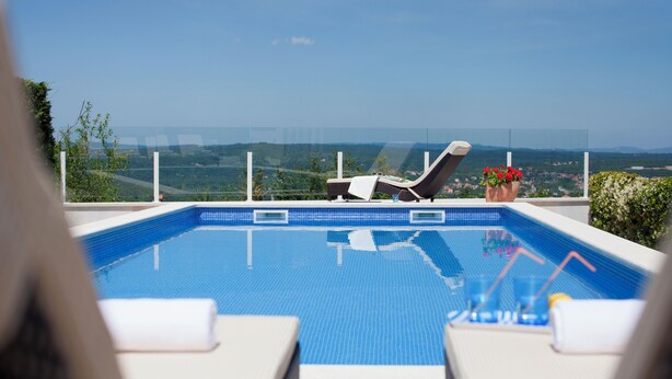 Una piscina con lettini e vista sul paesaggio.