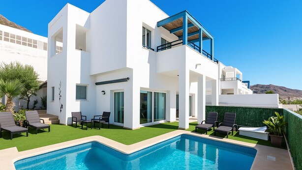 Une maison moderne à deux étages, dotée d’une piscine, d’un espace salon extérieur et offrant une vue sur les collines.