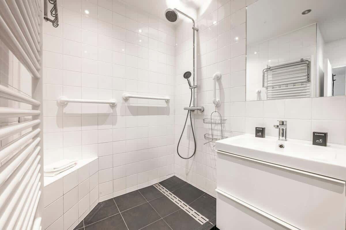 A modern bathroom with a shower, toilet, and sink.