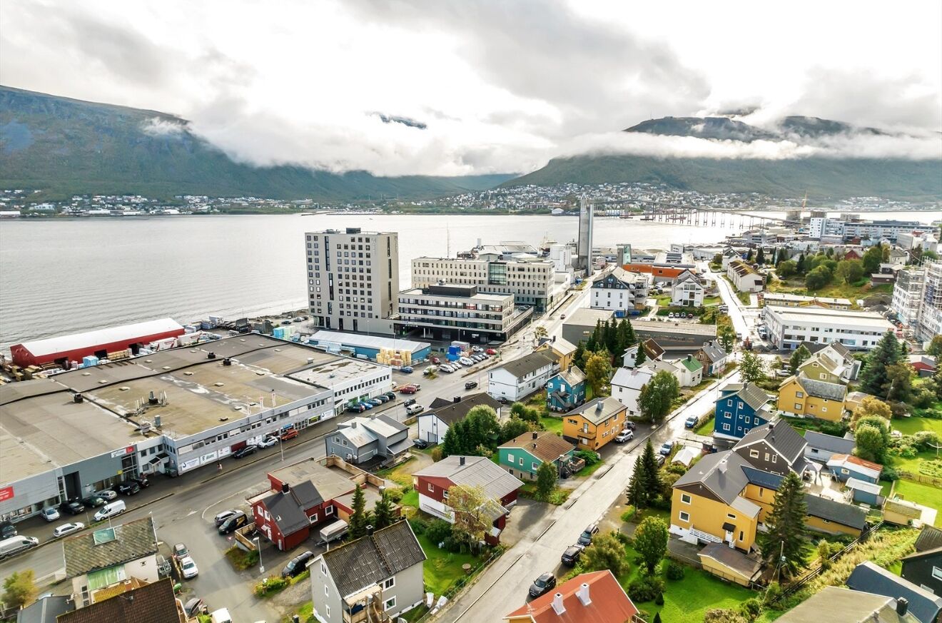 A coastal town with a mix of residential and commercial buildings, a prominent church, and a bridge in the background.