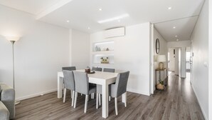 A modern dining area with a white table and grey chairs, a floor lamp, and a hallway leading to other rooms. - F rum Terrace by Minhos Guest (Braga)