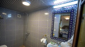 A bathroom with patterned tiles, a toilet, a sink, a mirror, and a shower. - Spacious 5-bedroom riad in lovely Fès with AC and fitness room (Fès)