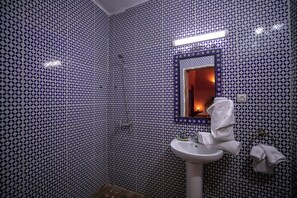A bathroom with patterned walls, a sink, a mirror, and a towel rack. - Spacious 5-bedroom riad in lovely Fès with AC and fitness room (Fès)