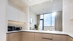 A modern kitchen with a microwave, coffee maker, and a large window with curtains. - LUX  The Phantom Sky Pool Suite (Dubai)