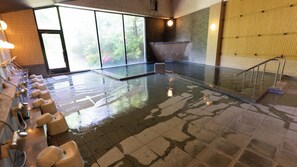 A large indoor swimming pool with a tiled floor, a glass barrier, and a row of toilets on one side. - Kikuchi Sasanoya (Kikuchi)