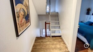 A narrow hallway with a wooden floor, a white staircase, and a framed picture on the wall. - Magnificent house ideally located in st Valery sur somme (Saint-Valery-sur-Somme)