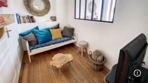 A cozy room with a bed, a small stool, a cat in a basket, and a television. - Magnificent house ideally located in st Valery sur somme (Saint-Valery-sur-Somme)