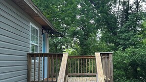 A wooden deck leading to a house with a blue door, surrounded by lush greenery. - Private Studio 12min from. Mercedes Benz/Downtown (Atlanta)