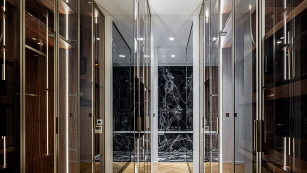 A hallway with mirrored walls and wooden flooring, leading to a room with a marble floor. - Avenue Niel - Place des Ternes - 2 chambres - Luxe (Paris)